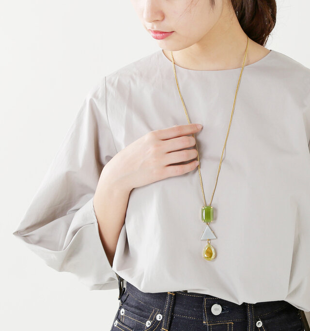 長いコードに大ぶりな3連モチーフのトップが印象的なネックレス。襟のある服の上からでもあわせられます。