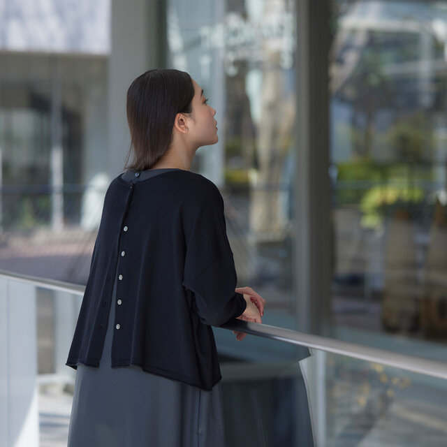 後ろにまわしたボタンをいくつか外して着ると、後ろ姿に遊び心を感じさせます。