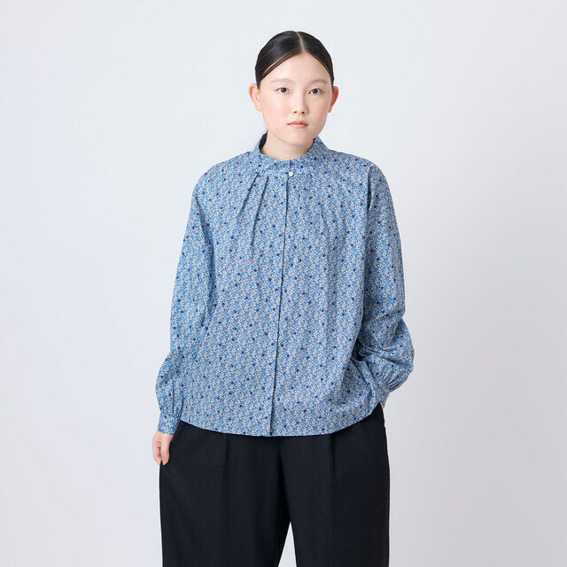 首元に施したタックがやわらかな立体感を生み、すっきりとしたスタンドカラーを上品に引き立てます。