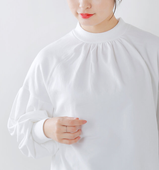やわらかいリブ仕立てのスタンドカラーにギャザーを寄せて女性らしいネックライン。首周りを優しく包み込むような着心地です。