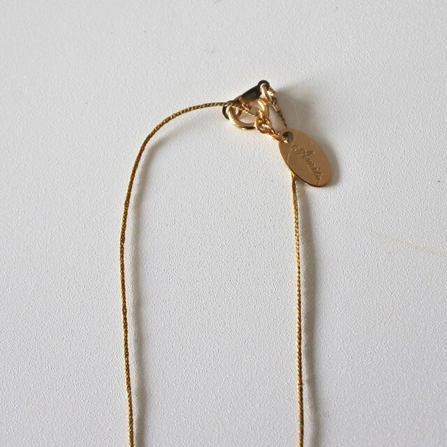 留め具部分は金属でできています。ブランドネームがあしらわれたプレートがアクセントに。