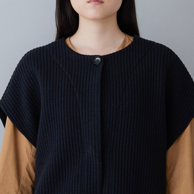 シンプルなネックラインに、一番上のボタンだけを見せたすっきりとした比翼仕立てです。