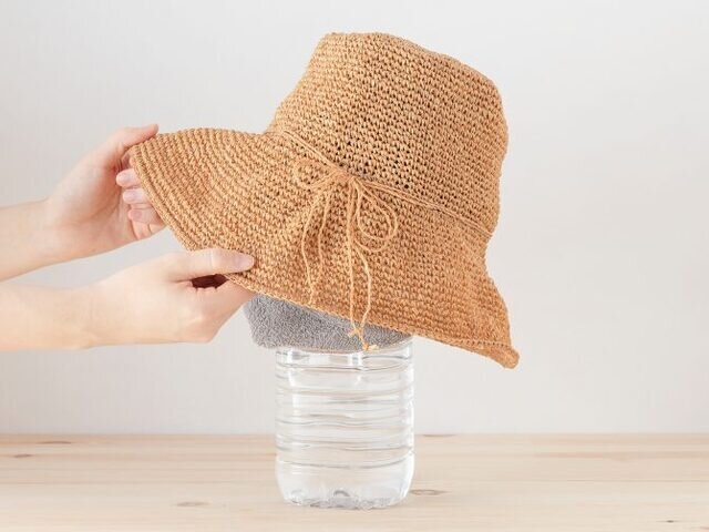 型崩れをしないように、帽子の中にタオルを詰めて保型し、2L のペットボトルにかぶせて干してください。