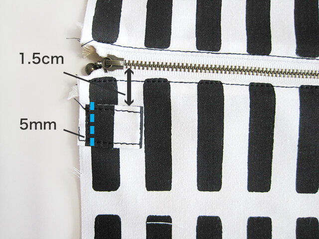 （7-2）できあがったタグを画像のように、表地（表面）の脇に5ｍｍ幅ステッチで縫い付けます。