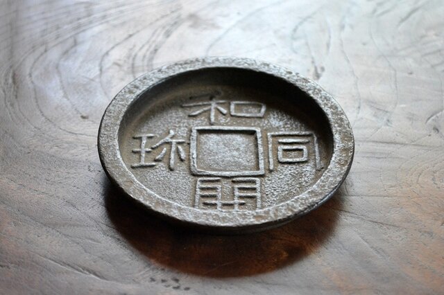 日本の最初の通貨と言われる「和同開珎」をモチーフとした古雅な趣あふれるコースター。