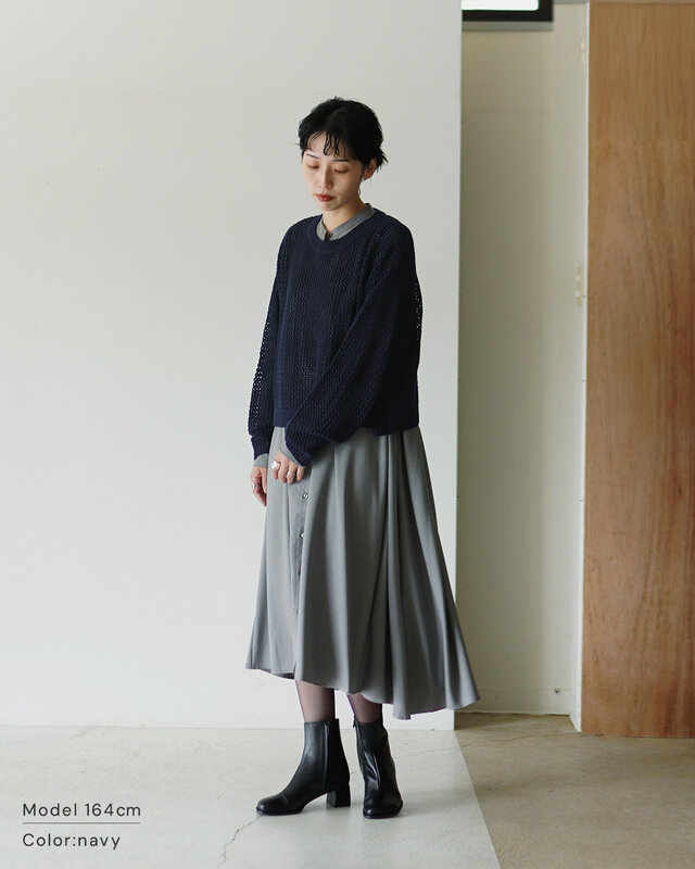 シアーな編み目からのぞくワンピースのレイヤードが、抜け感とこなれを演出。シックな配色にモードなブーツでシャープさを効かせて。