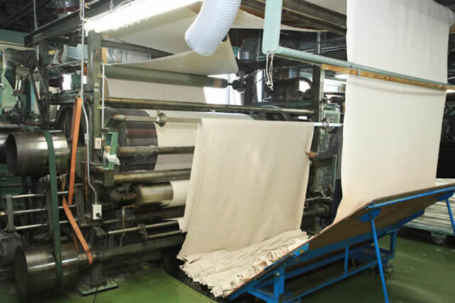 起毛師と呼ばれる専任の職人が機械を操る、毛布づくりの「要」の工程