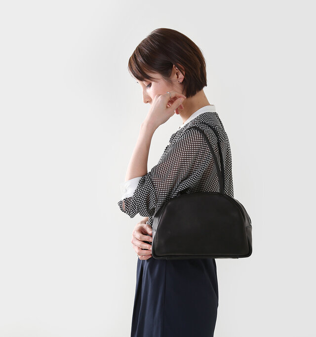 可愛らしいボリューム感と
プリミティブで幾何学的なデザイン、
レザーの柔らかな表情が
バランスされた都会的な印象のバッグ。
細めで女性らしい繊細さのある持ち手、
革の質感をふんだんに活かした
袋縫いの縫製。
女性らしさあふれるバッグなので、
よそいきだけでなく
普段使いにもぜひどうぞ。