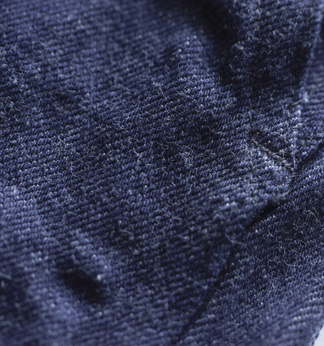 LENOのジーンズは旧式力織機（シャトル織機）によって織られています。
旧式の織機では、現在主流の高速織機の６分の１のスピードで縦糸に無駄な力を加えず織ることで、生地の表面が凸凹とした風合いのある生地になります。これが着用を繰り返す事で奥行きのある美しいフェードを生み出します。更に横糸のテンションを調節することにより、厚みがあっても柔らかい風合いになるよう調節をしています。旧式の力織機を使用して織られた証である生地の「耳」は胸ポケット裏側に見る事ができます。