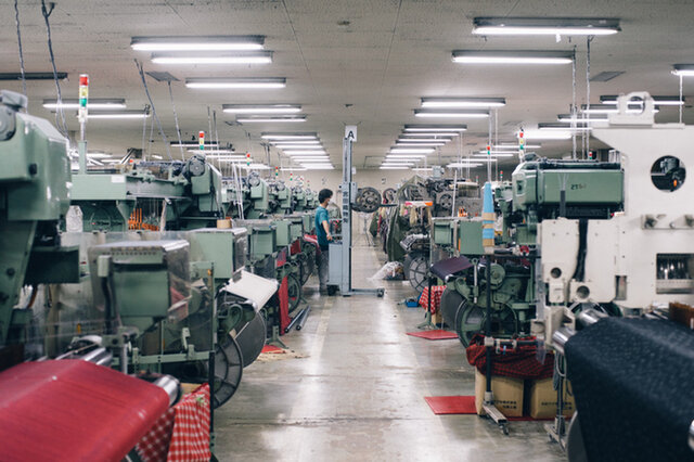 糸から布を織るまでの工程を担当する職人が、糸と生地を細かくチェック。織機の特徴を把握して、糸1本単位で発生するエラーに即座に対応するという。