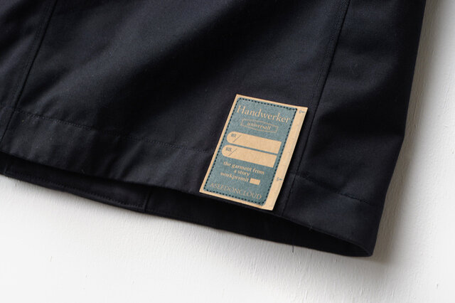 右裾（背中側）には、Handwerkerコレクション定番の紙パッチを配置。これは取り外さずに洗濯いただけます。