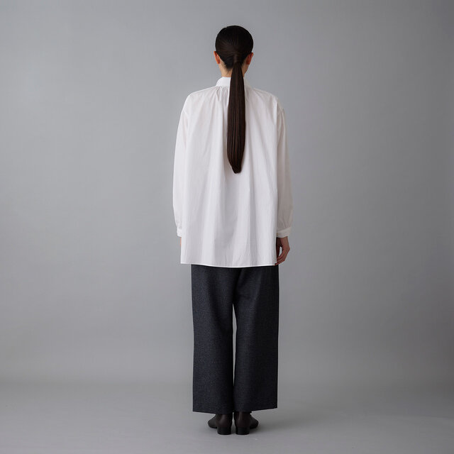 首元に寄せた繊細なギャザーが生地のしなやかさを引き立て、後ろ姿にやわらかな表情を生み出します。