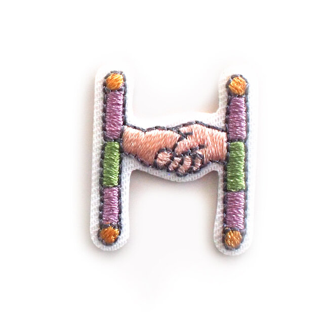 Hのデザインは握手するふたり。

友情や結びつきをイメージしたモチーフです。