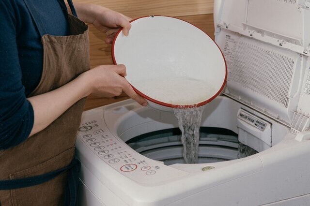洗濯機にまずお湯（ぬるま湯）を入れ、軽量した粉石けんを徐々に加え、泡立たせます。写真のようにボウルなどの容器に粉せっけんを入れ、ぬるま湯でよく溶かしてから洗濯機へ直接投入するのもおすすめです。
