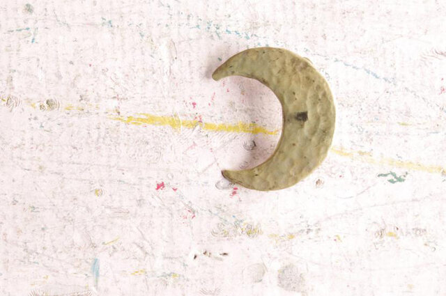 三日月のブローチはそのシンプルゆえ、叩きだしの味わいが存分に楽しめる作品。